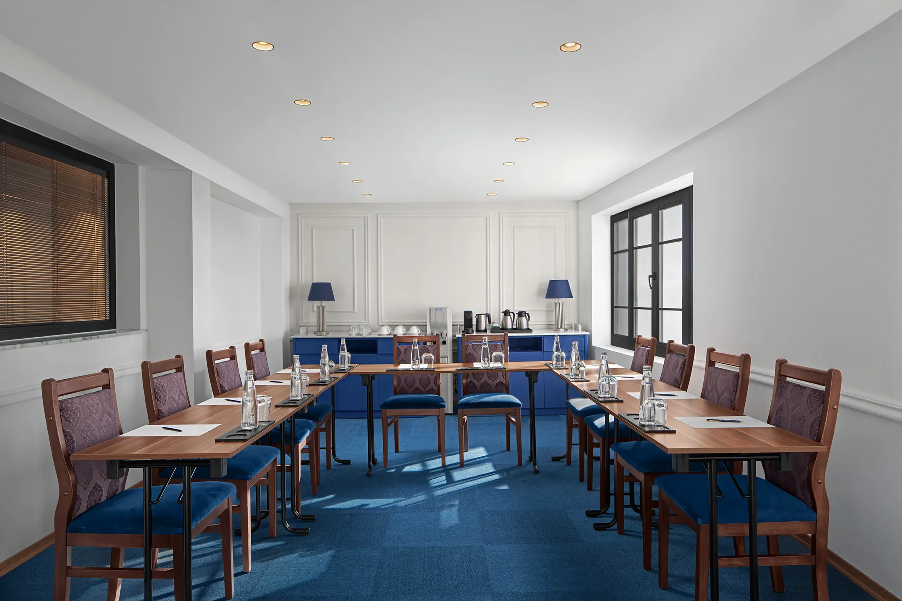 Nissim Meeting Room set up in a U-shape with blue upholstered chairs