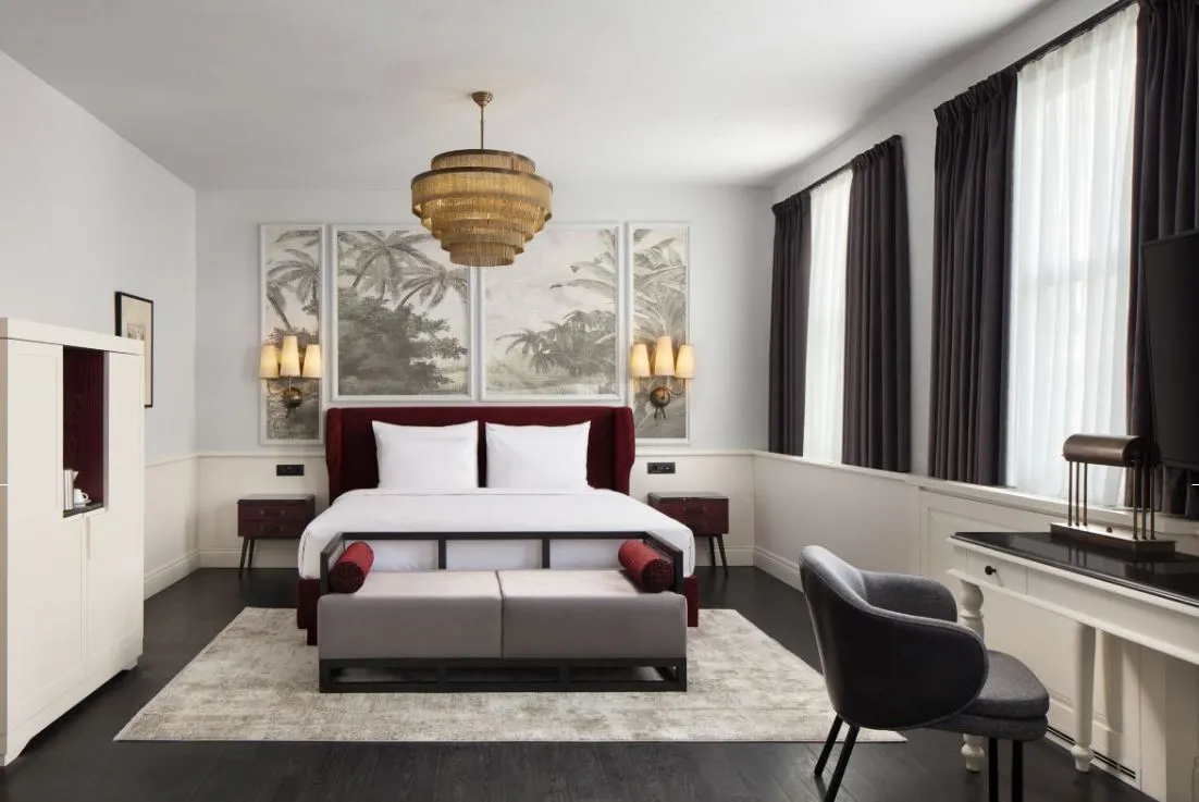 Suite bedroom with a king bed and bench