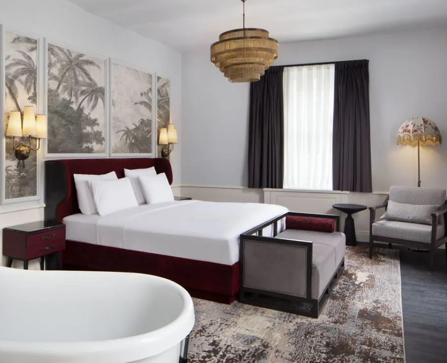 Suite bedroom with bathtub at the foot of the bed