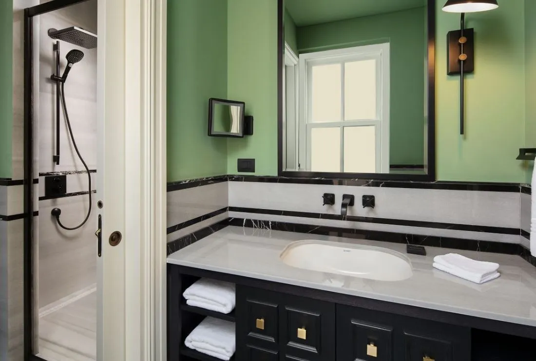 Suite bathroom with green walls and rain shower