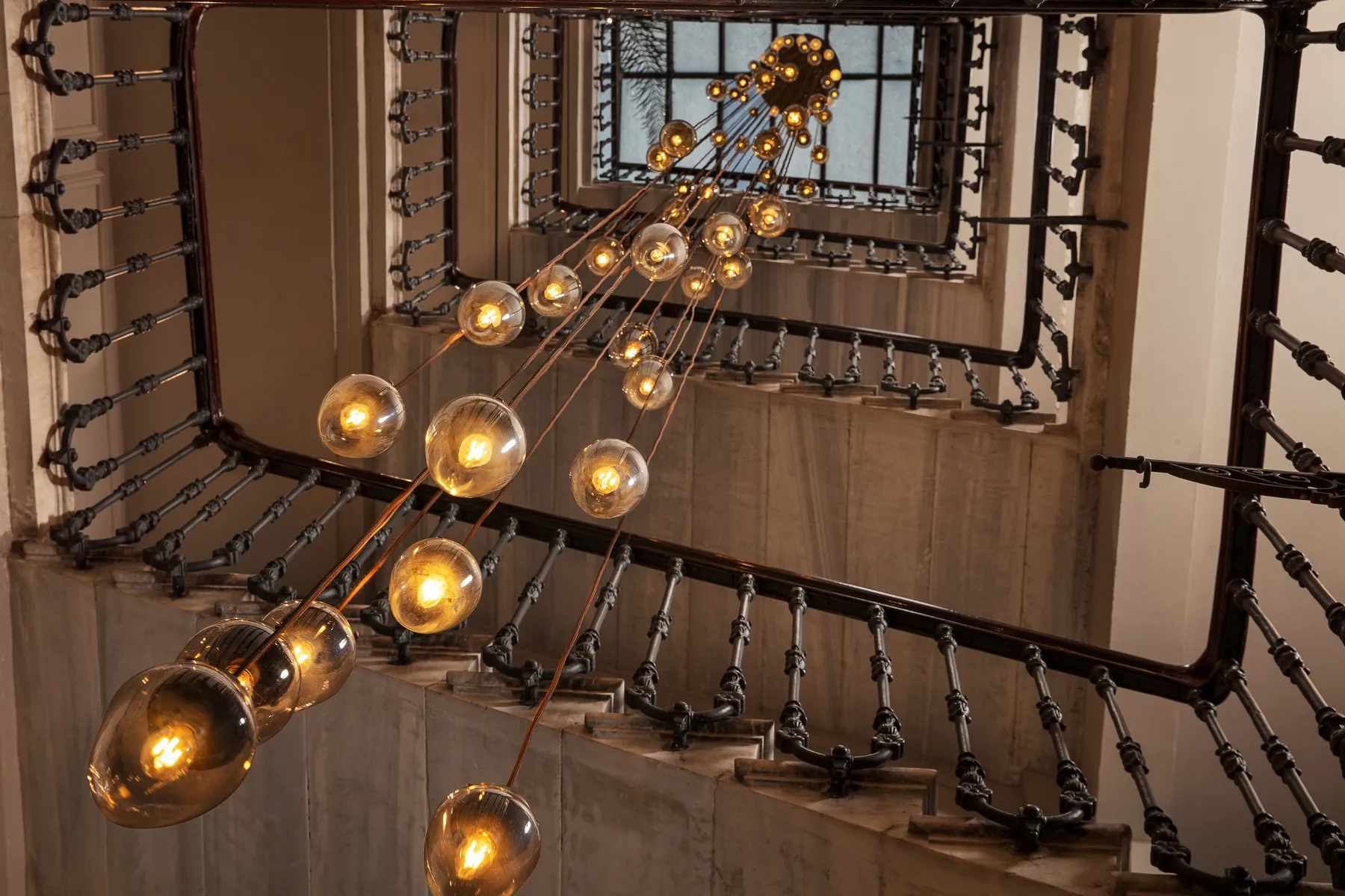Globe chandelier hanging through the historic stairwell