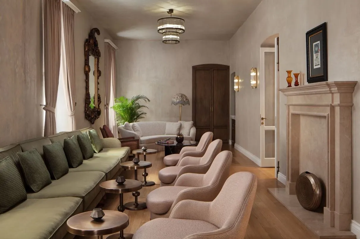 Long lounge with a green banquette and a fireplace
