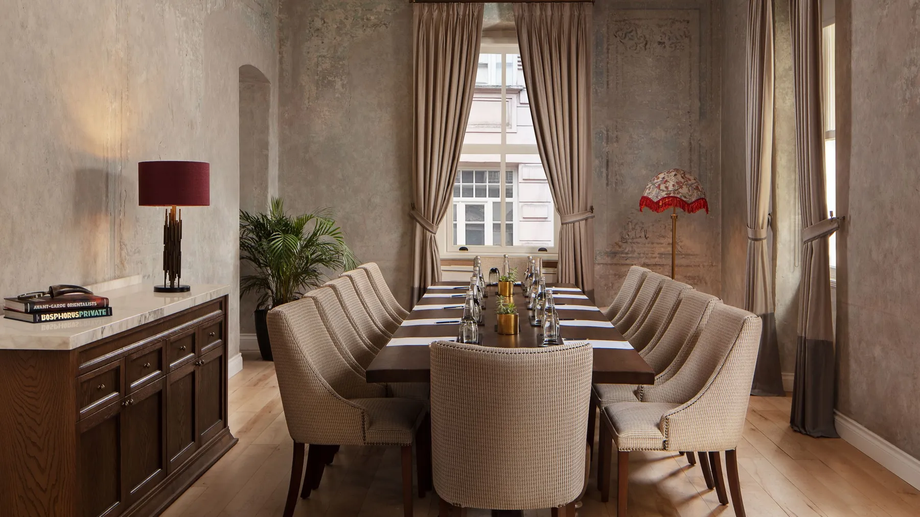 Room 1874 set for a board meeting with a long table and upholstered chairs