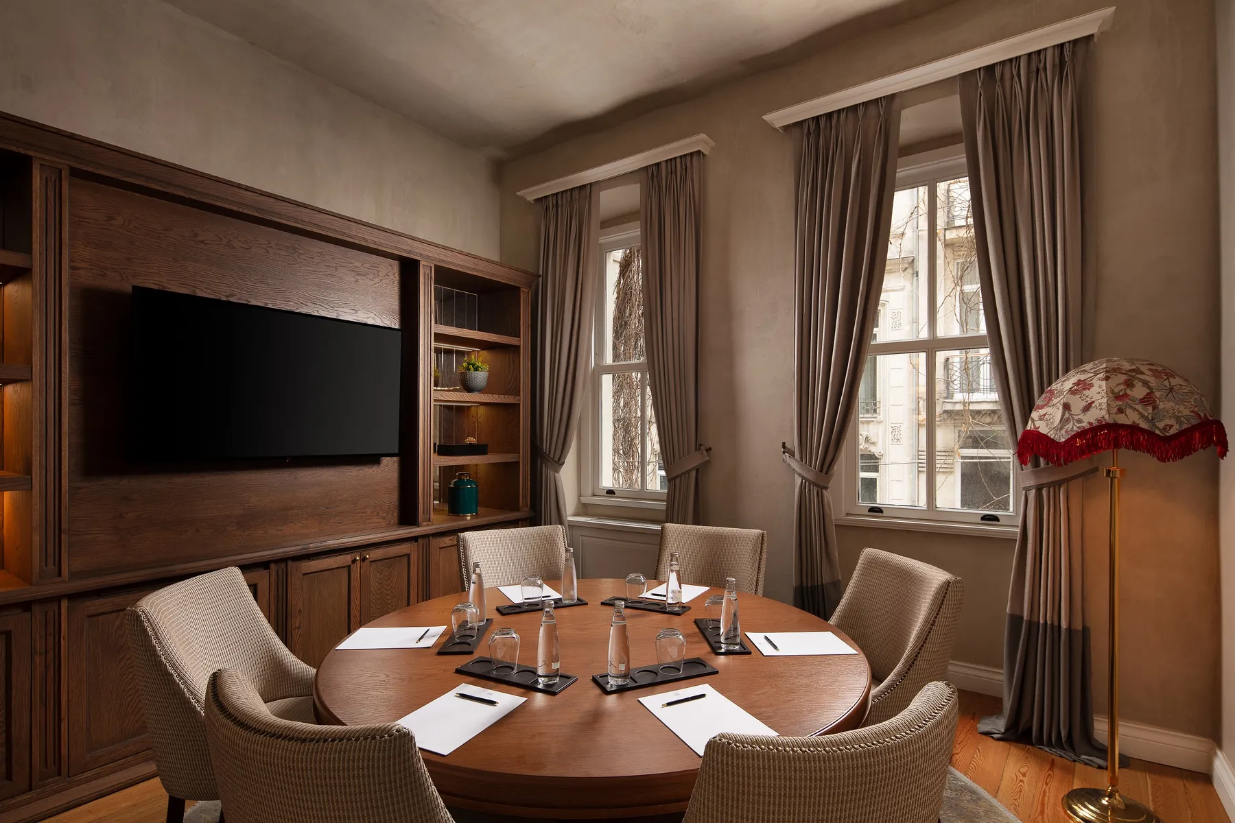 Round meeting table with a wall-mounted screen