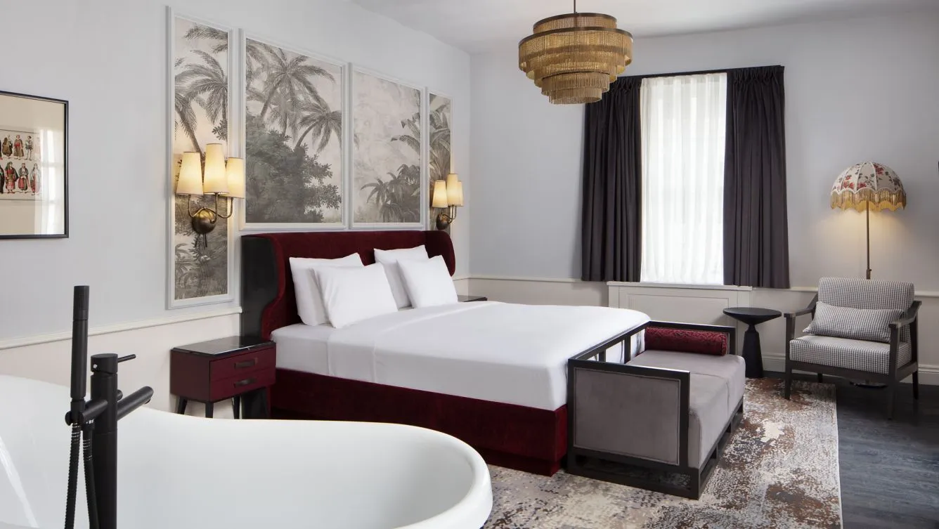 Adahan Charm Suite bedroom with a king bed and freestanding bathtub